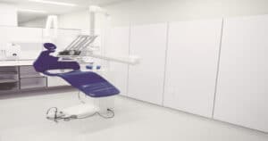Sala de atendimento do consultório odontológico vazia, com a cadeira do dentista disposta no centro.