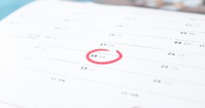 Calendário colocado sobre uma mesa com a data 18 circulada em vermelho.